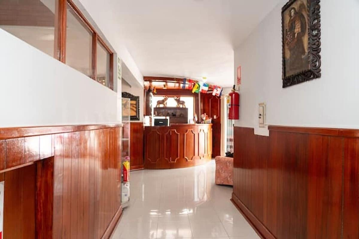 A hallway with wooden paneling, a reception desk, and a framed picture on the wall.