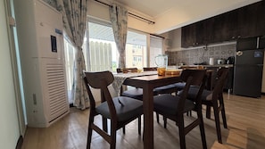 A kitchen with a dining table, chairs, and a refrigerator. - Embun at Sumbiling (Bandar Seri Begawan)
