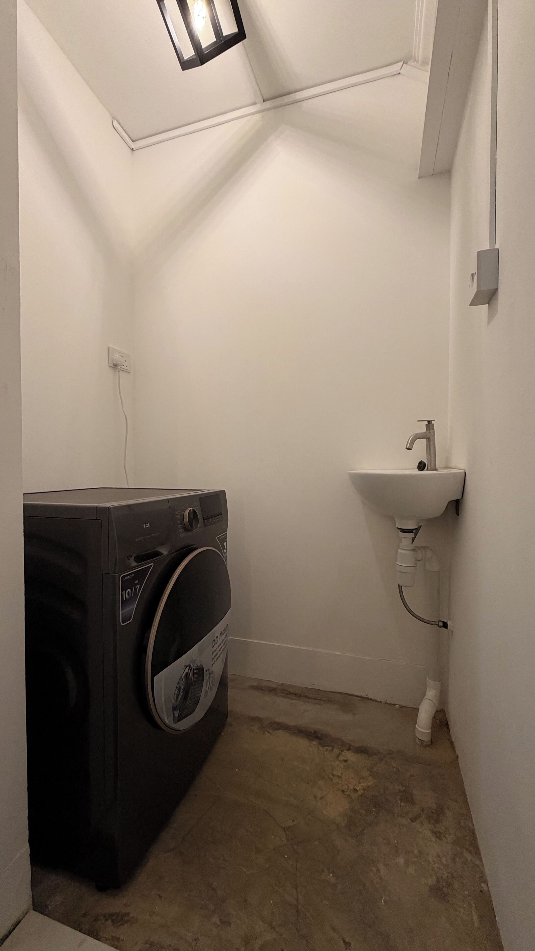 A compact laundry room with a washing machine and a sink.
