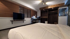 A bedroom with a bed, a television on a shelf, a desk with a chair, and a wardrobe. - Embun at Sumbiling (Bandar Seri Begawan)