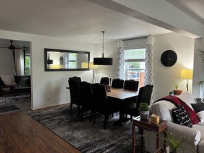 Un coin repas avec une table, des chaises et un miroir au mur.
