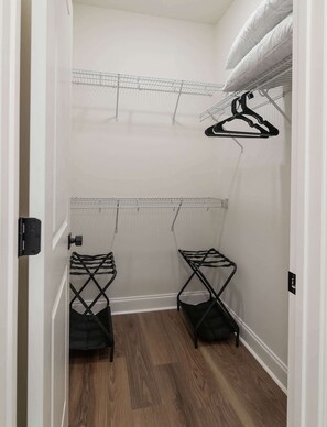 A walk-in closet with metal drying racks and a mirrored closet door.