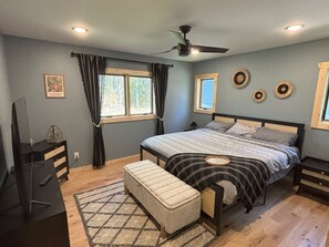 A bedroom with a bed, a television, a desk, and a window with curtains. - Hayward Northwoods Escape -ATV Trails, Pond + Kayaks & Firepit (Hayward)