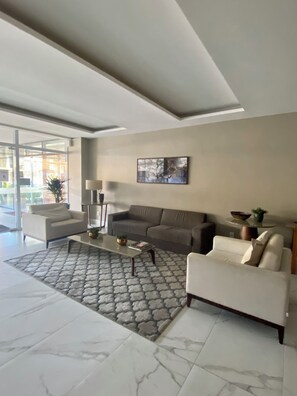 A modern living room with a sofa, armchairs, a coffee table, and a rug. - 2802 Unique Estudio Caragem (Belem)