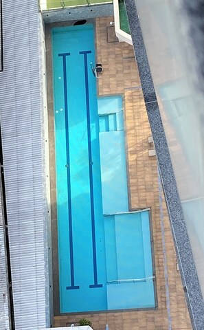 Une piscine de deux couloirs, située à côté d’un bâtiment dont le sol est carrelé.