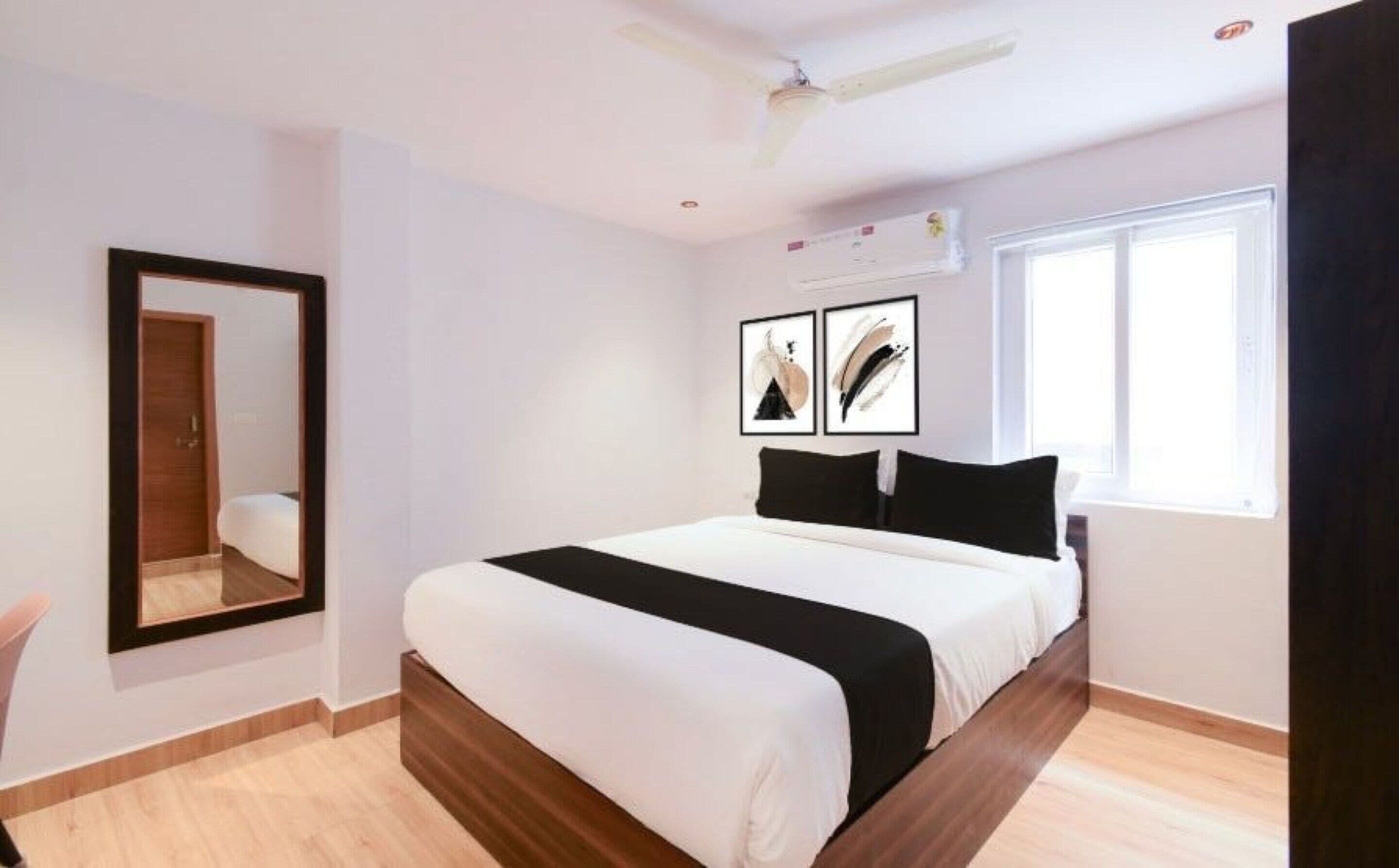 Een slaapkamer met een bed, een plafondventilator, een raam en kunstwerken aan de muur.