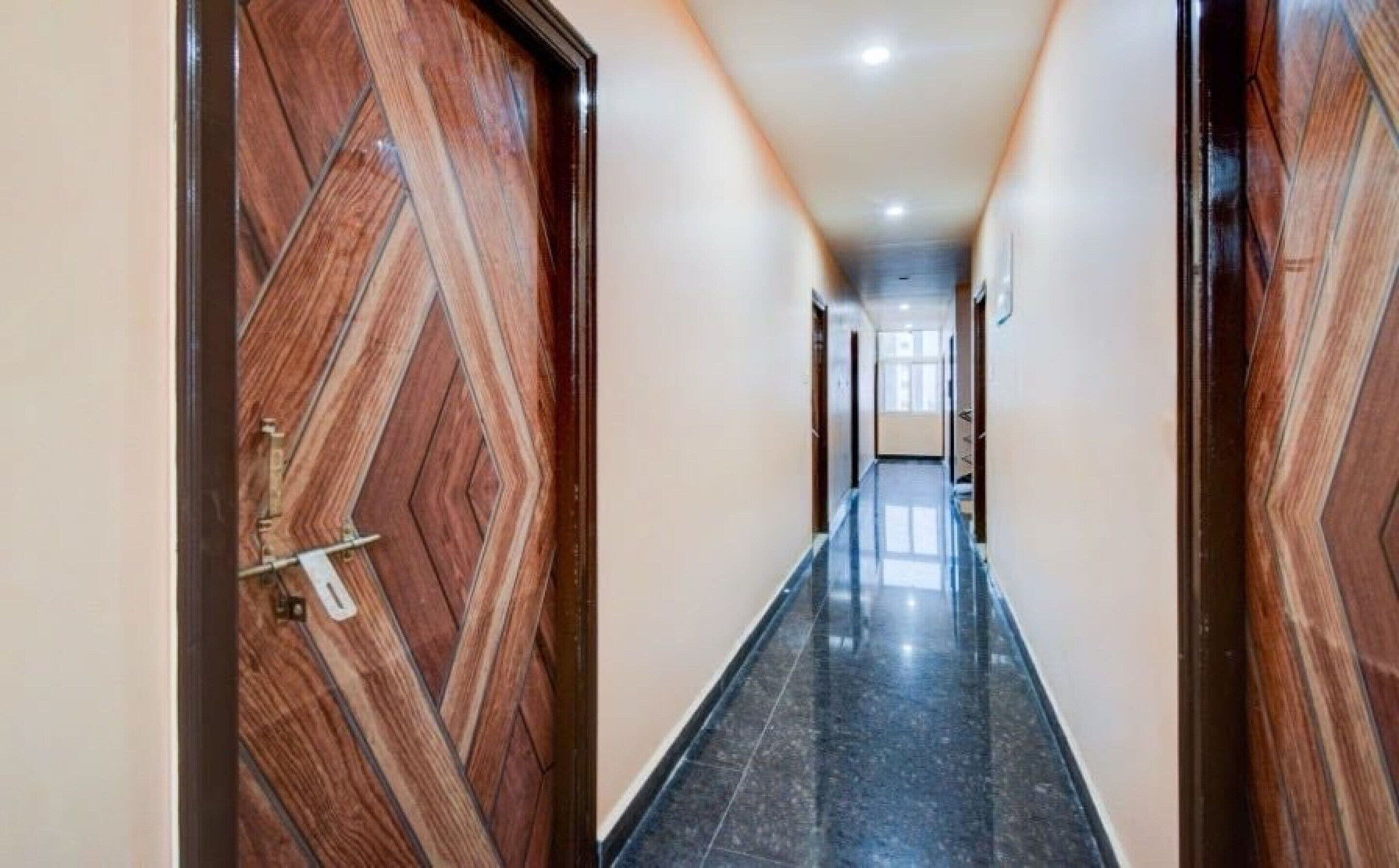 Um corredor com portas de madeira e chão de azulejos.