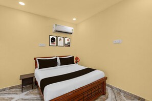 A hotel room with a bed, an air conditioner, and framed artwork on the wall. - Classic Ramoji Film City (Hyderabad)