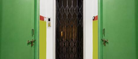 A hallway with two green doors, each marked with a number.