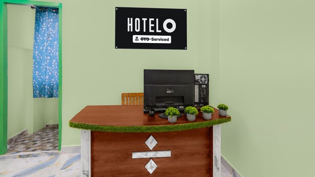 Balcão de recepção de hotel com uma placa indicando que o serviço é realizado pela OYO.