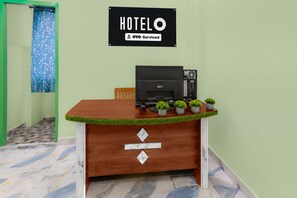Un mostrador de recepción de hotel con un cartel que indica que el servicio es proporcionado por OYO.