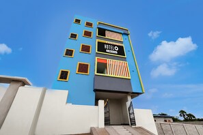A hotel building with a blue facade, multiple windows, and a sign indicating it is serviced by OYO. - Classic Ramoji Film City (Hyderabad)