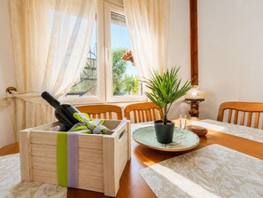 Ein Holztisch mit einem Blumentopf, einer Flasche und einer Kerze.