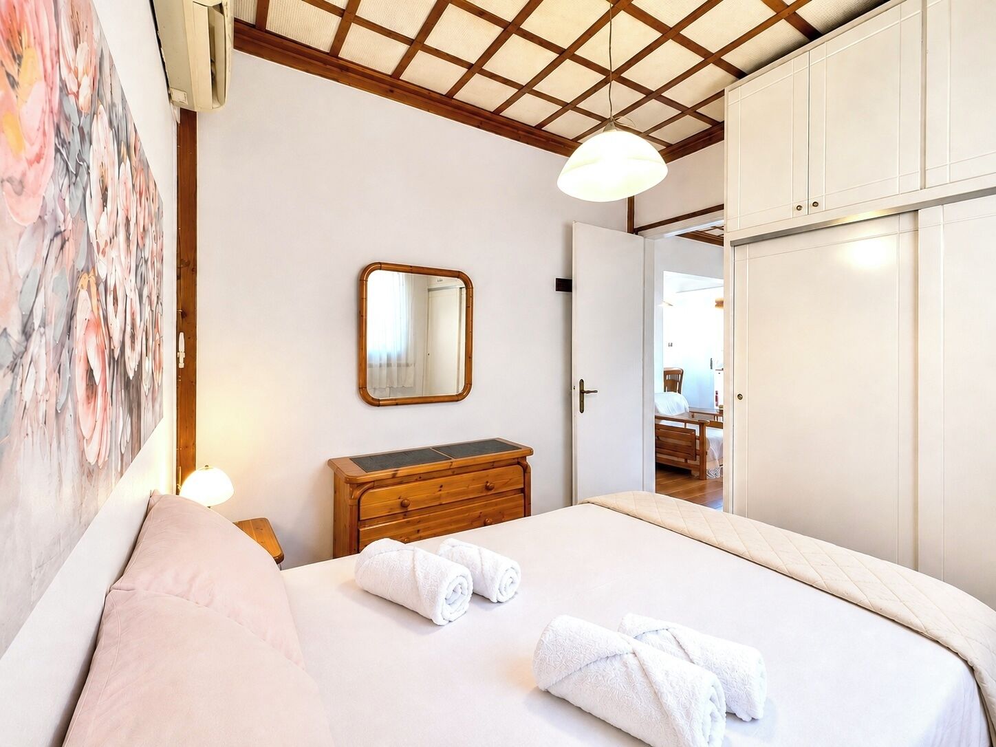 Ein Hotelzimmer mit Bett, Schminktisch, Spiegel und Kleiderschrank.