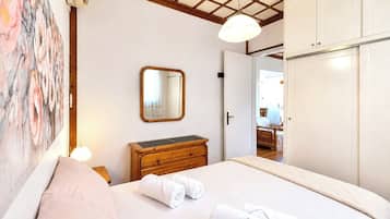 Ein Hotelzimmer mit Bett, Schminktisch, Spiegel und Kleiderschrank.