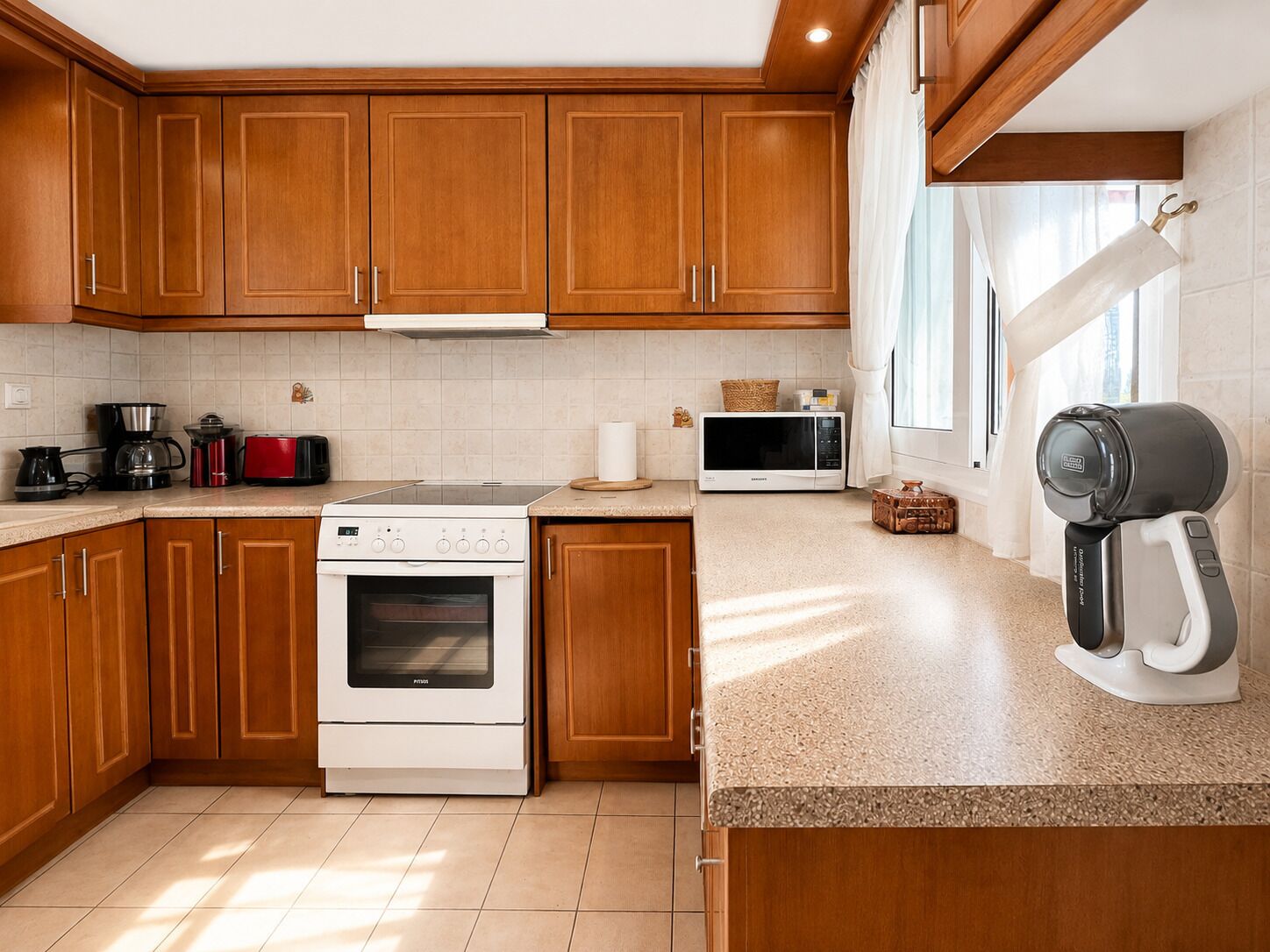 A modern kitchen with wooden cabinets, a stainless steel range, a microwave, and a coffee maker.