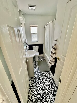A narrow bathroom with a white sink, toilet, and bathtub. - Family & pet friendly 3 BDR, walk to restaurants & nightlife in Murray Hill (Jacksonville)