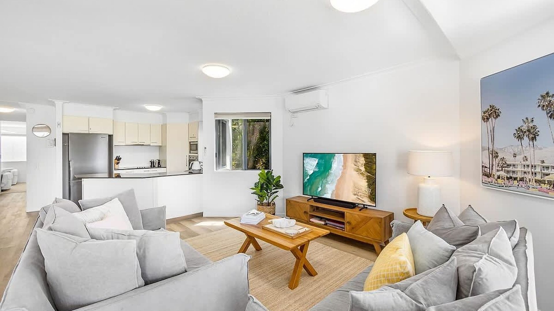 A modern living room with a sofa, coffee table, and a television.