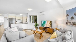 A modern living room with a sofa, coffee table, and a television. - Belmore Palms Sunshine Beach (Sunshine Beach)