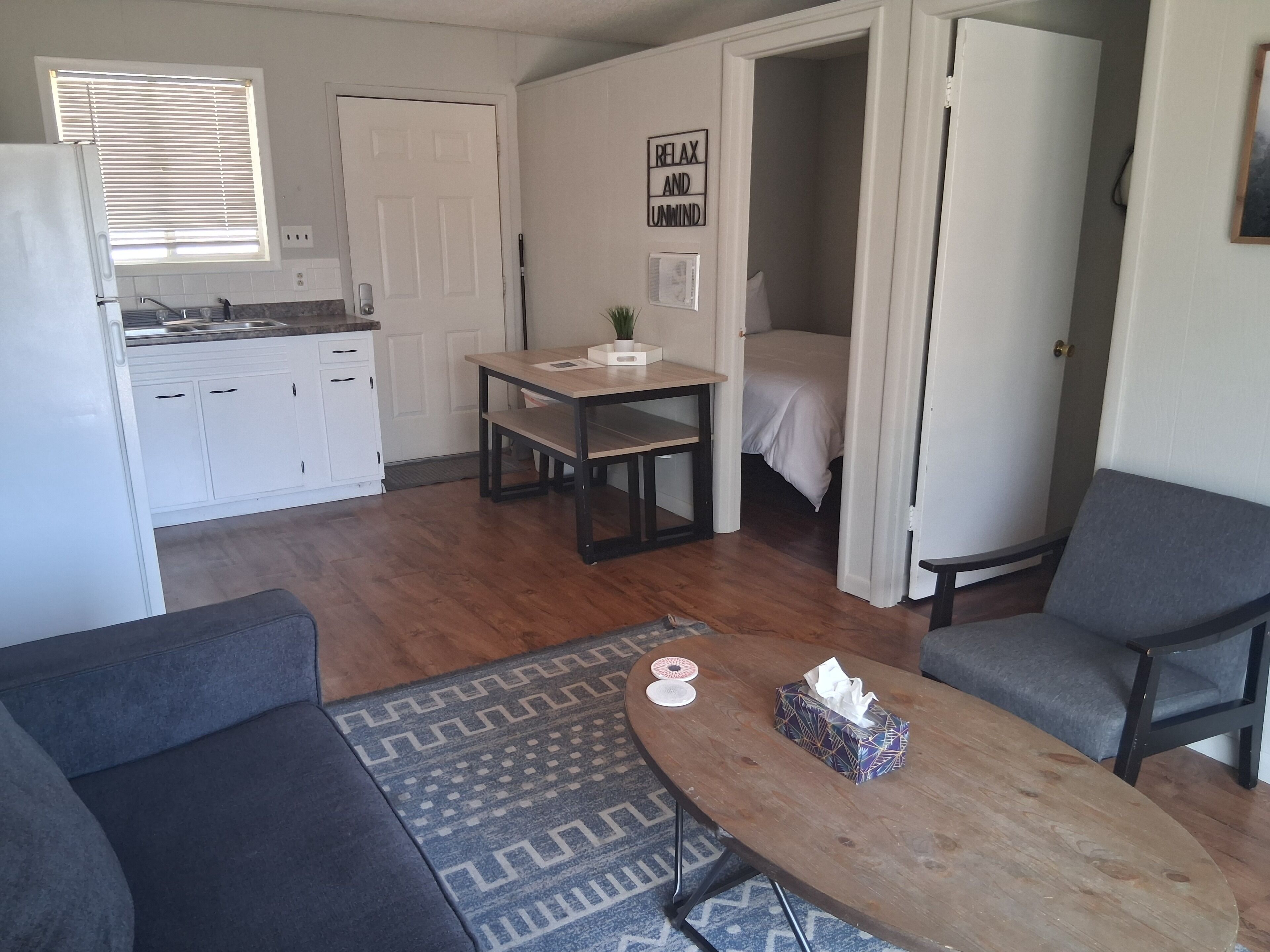 A compact living space with a kitchenette, a dining area, and a bedroom.