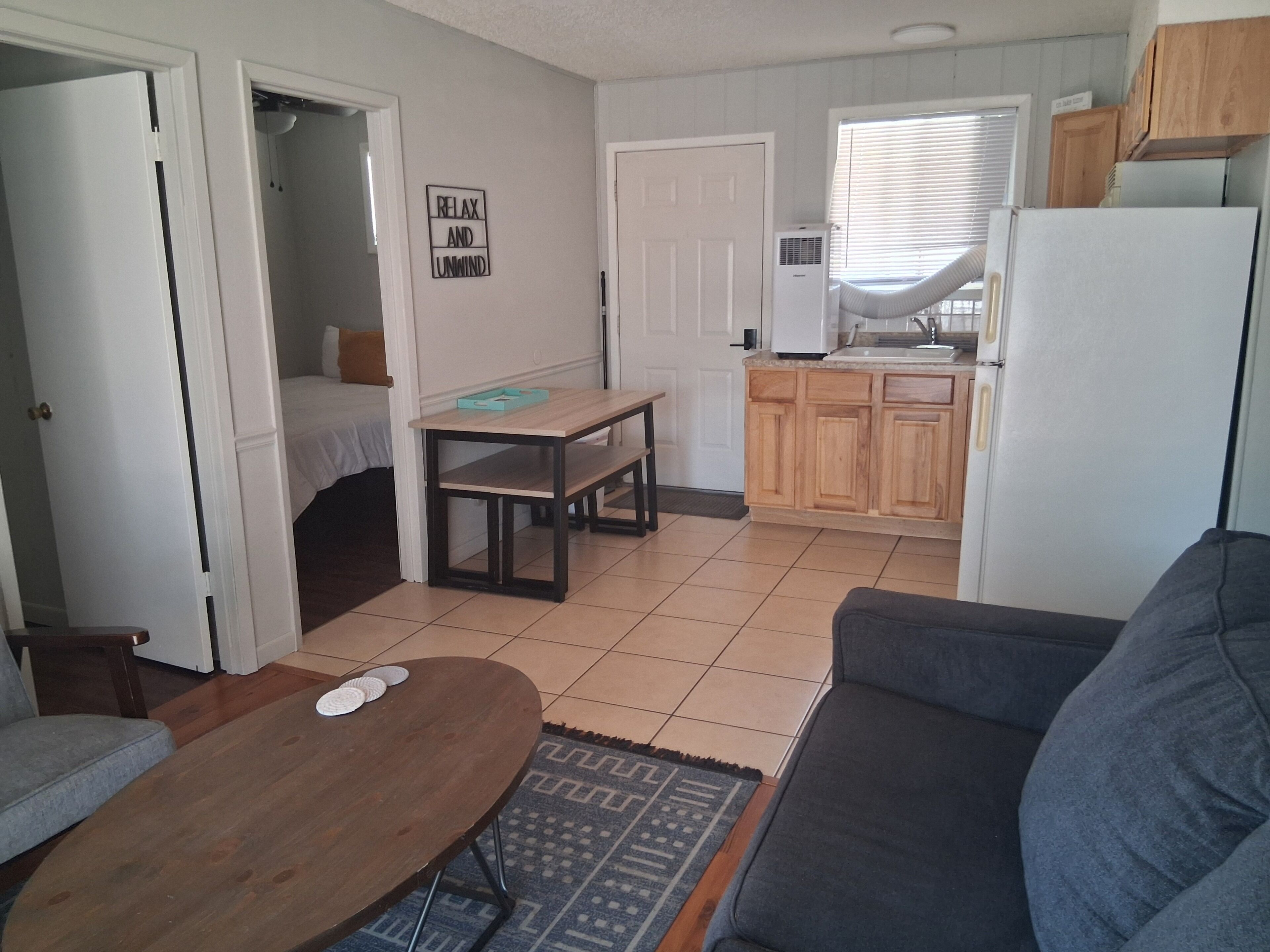 A compact living space with a kitchenette, a dining area, and a seating area.