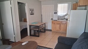 A compact living space with a kitchenette, a dining area, and a seating area.