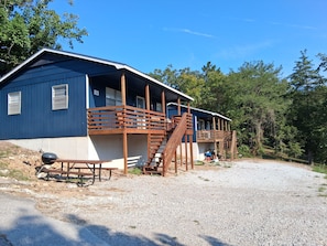 Un edificio de dos pisos con una escalera de madera y un porche cubierto.