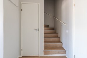 A staircase with wooden steps and a white door. - Stylish 2-bedroom family apartment w/ sauna, parking (Helsinki)