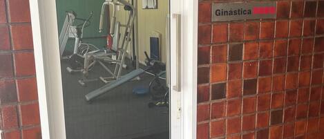 Puerta con un letrero que dice 'Ginástica', indicando una zona de gimnasio.