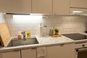 Une cuisine équipée d’un évier, d’un plan de travail et de placards.