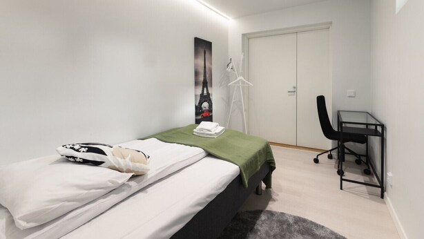 A bedroom with a bed, a desk, and a wardrobe. - Brand new house with four bedrooms, parking, sauna, patio (Vantaa)