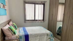 A bedroom with a bed, a bedside table, a nightstand, a window with blinds, and a wardrobe. - 2802 Parc Apto 3 qtos Luxo com Garagem (Belém)