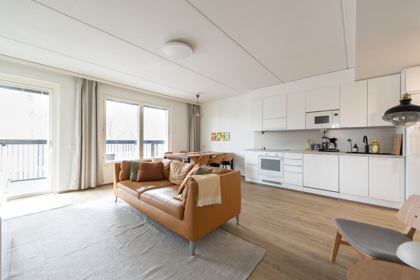 Un apartamento moderno con sala de estar, cocina y balcón.