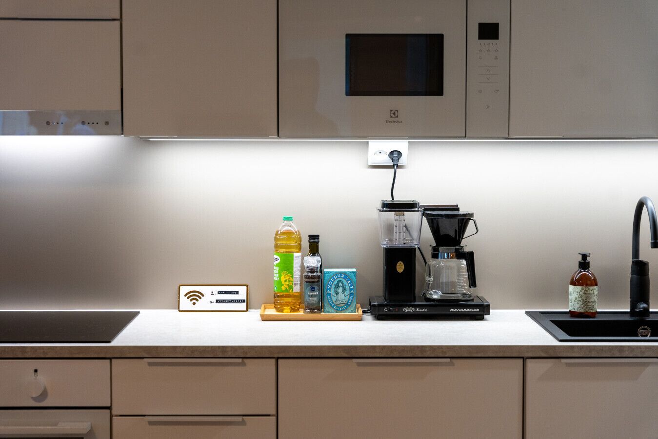 A kitchen with a coffee maker, a microwave, and a Wi-Fi symbol on the wall.