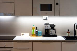 Eine Küche mit Kaffeemaschine, Mikrowelle und WLAN-Symbol an der Wand.
