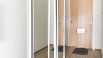 A hallway with a sliding glass door, a wooden door, and a carpeted floor.