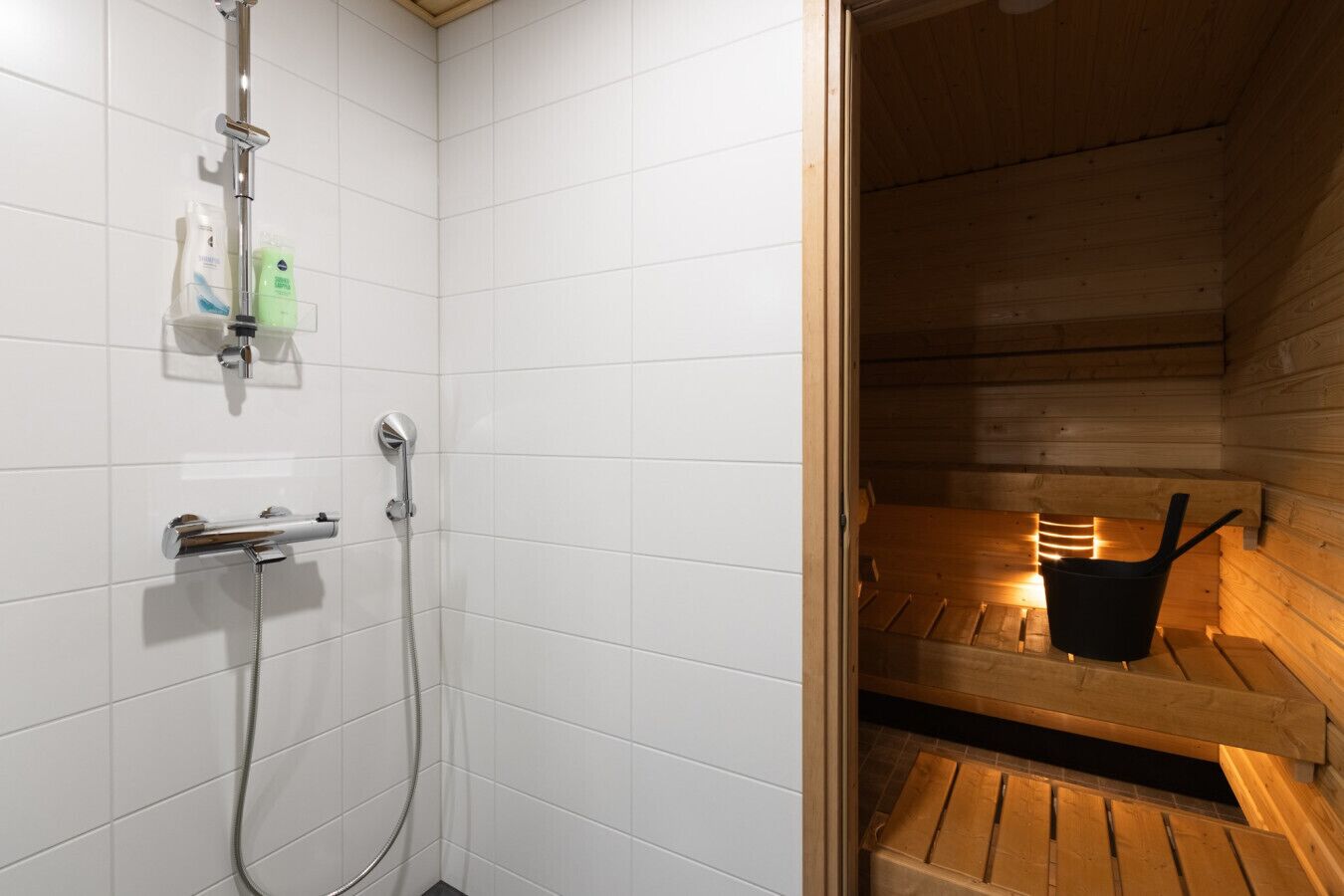 A shower area with a chrome showerhead and a handheld shower attachment.
