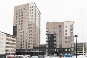 Monikerroksinen asuinkerrostalo, jossa on moderni arkkitehtoninen ilme ja jossa yhdistyvät erilaiset ikkunatyypit ja parvekkeet.