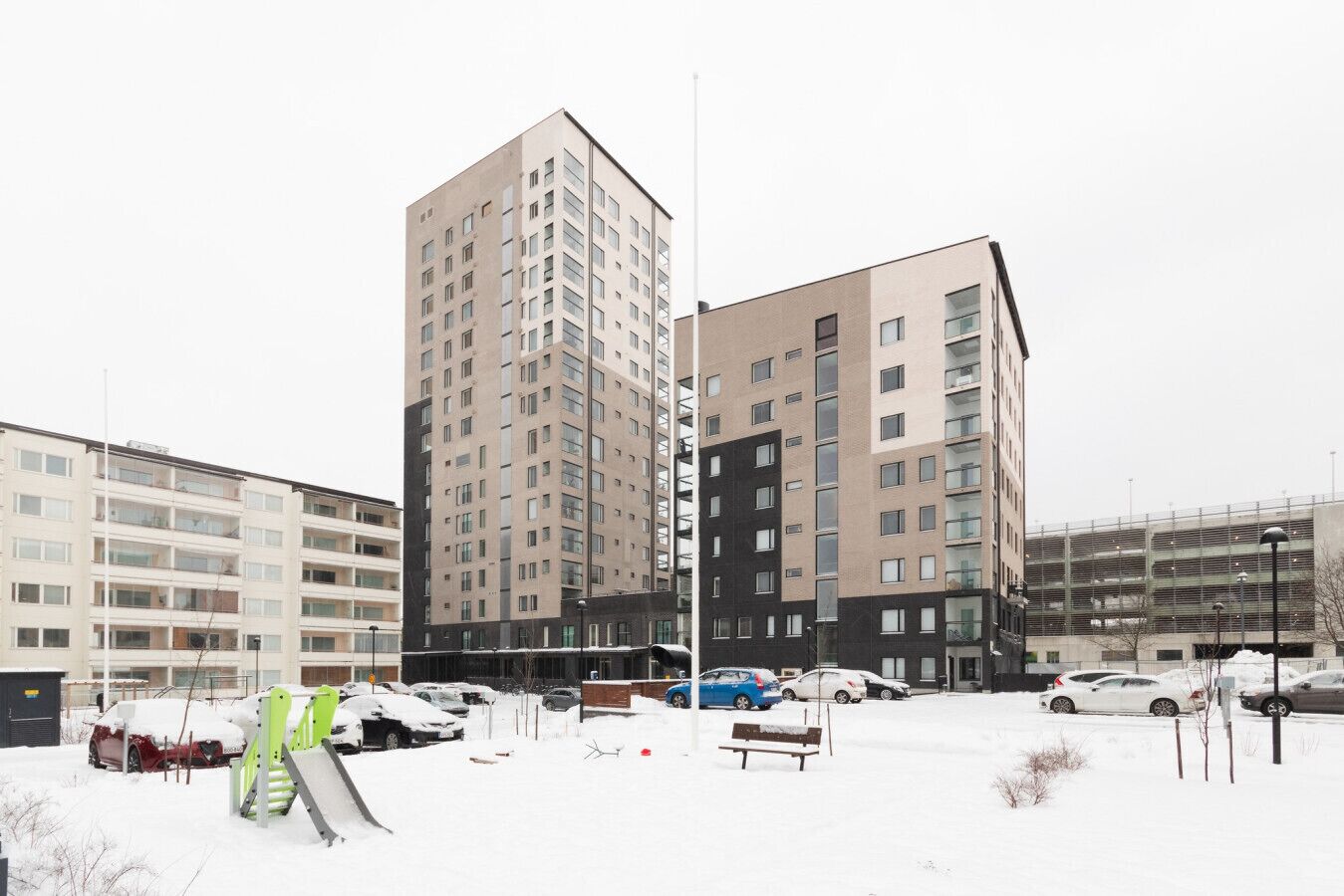 A multi-story residential building with a parking area in front.