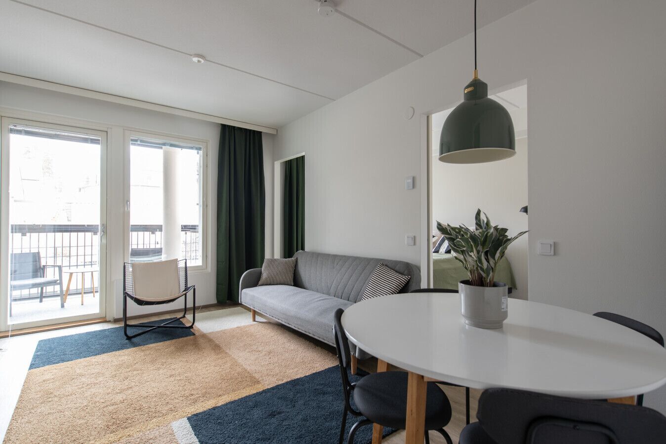 Un salon moderne avec un canapé, une table à manger et une plante en pot.