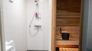 Baño con inodoro, ducha y zona de sauna.