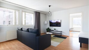 Ein modernes Wohnzimmer mit einer Couch, einem Fernseher und einem Essbereich.