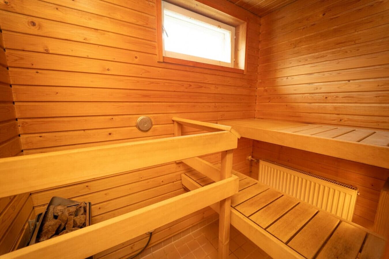 Una sauna de madera con bancos y una ventana.