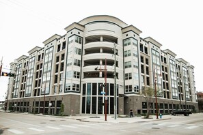 A multi-story residential building with a curved facade, large windows, and a central entrance. - Downtown Houston Skyline Stay, Steps to Daikin Park B (Houston)