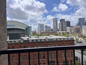 A cityscape with a prominent building labeled 'LILLER WAGON WORKS' and a modern stadium in the background. - Downtown Houston Skyline Stay, Steps to Daikin Park F (Houston)