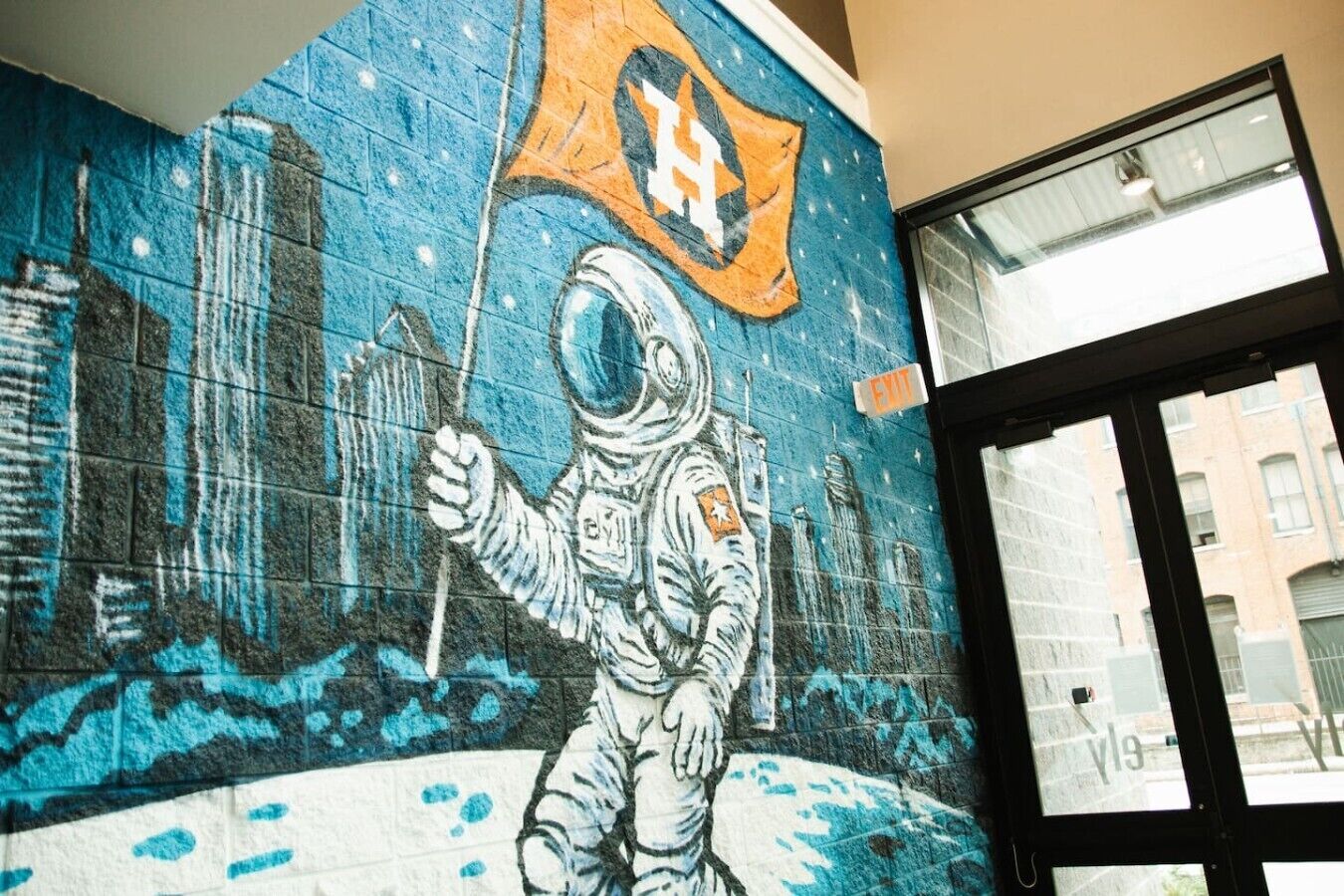 A mural of an astronaut with a flag, a window, and an exit sign.