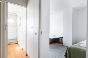 Une chambre d’hôtel avec un lit, un bureau et une vue sur un couloir.