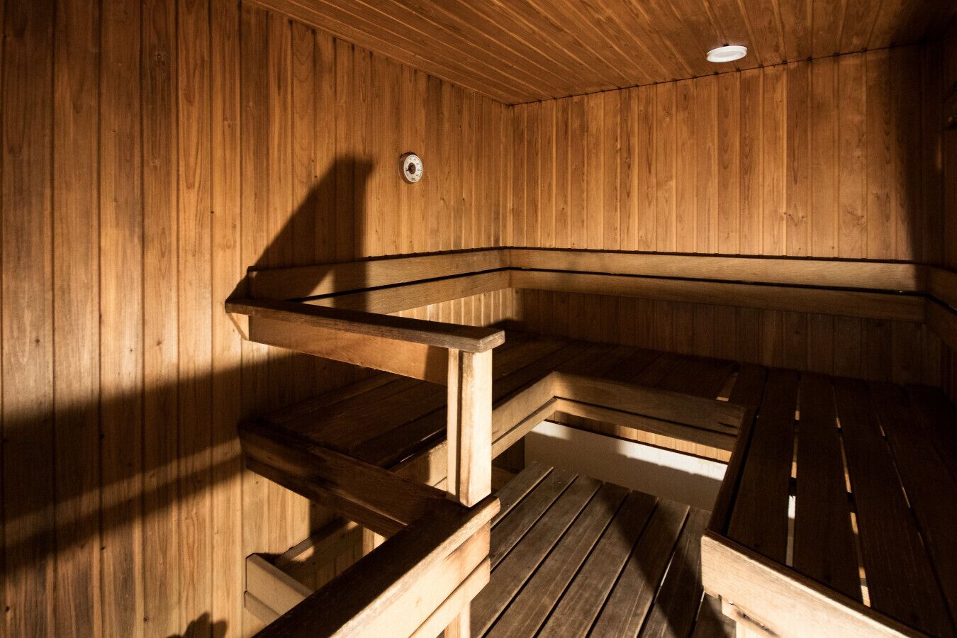 A sauna with wooden benches and a sloped ceiling.