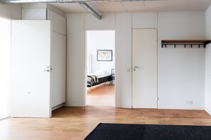 A room with a bed, a door, and a coat rack.