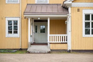 A two-story building with a porch and a front door.